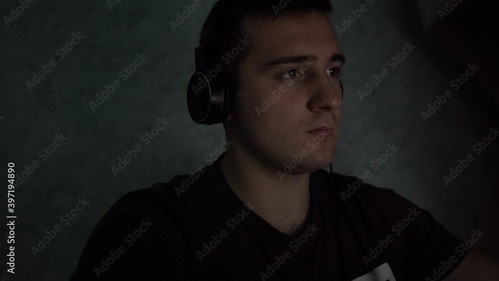 a man playing computer games at night a man playing computer games at night