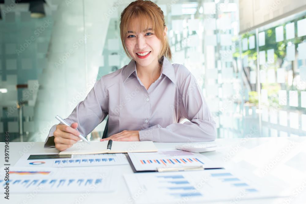Young Charming asian businesswoman sitting working on laptop in office. Young Charming asian businesswoman sitting working on laptop in office.
