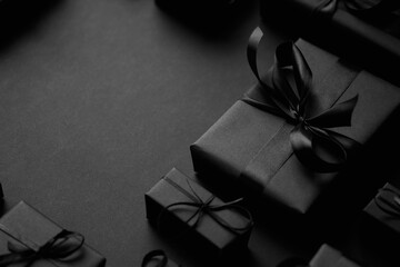 A pile various size black boxed gifts placed on stack. Christmas concept.