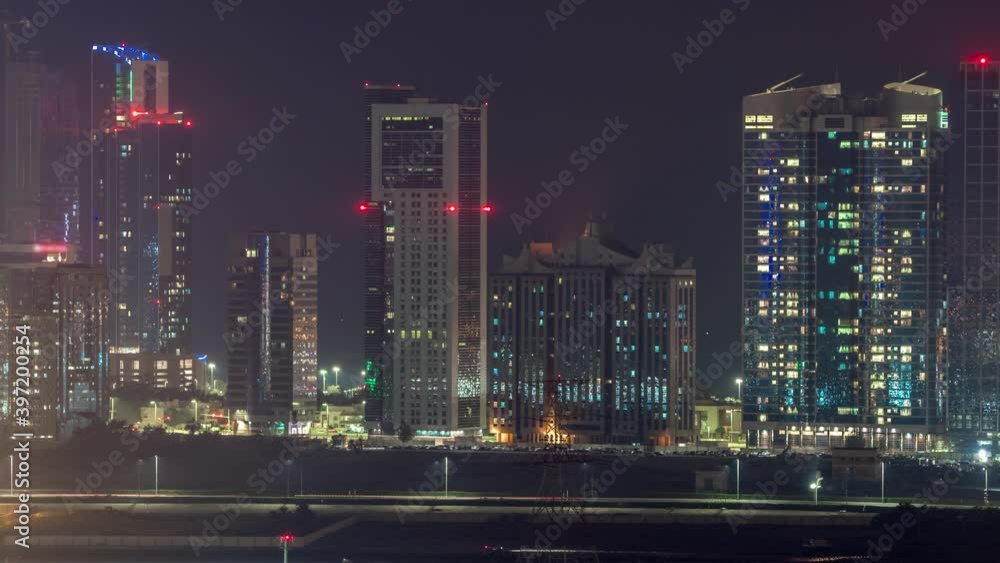 Skyscrapers on Al Reem and Al Maryah Island in Abu Dhabi night timelapse from above. Aerial citiscape from Al Reem Island with illuminated buildings. Traffic on the road Skyscrapers on Al Reem and Al Maryah Island in Abu Dhabi night timelapse from above. Aerial citiscape from Al Reem Island with illuminated buildings. Traffic on the road