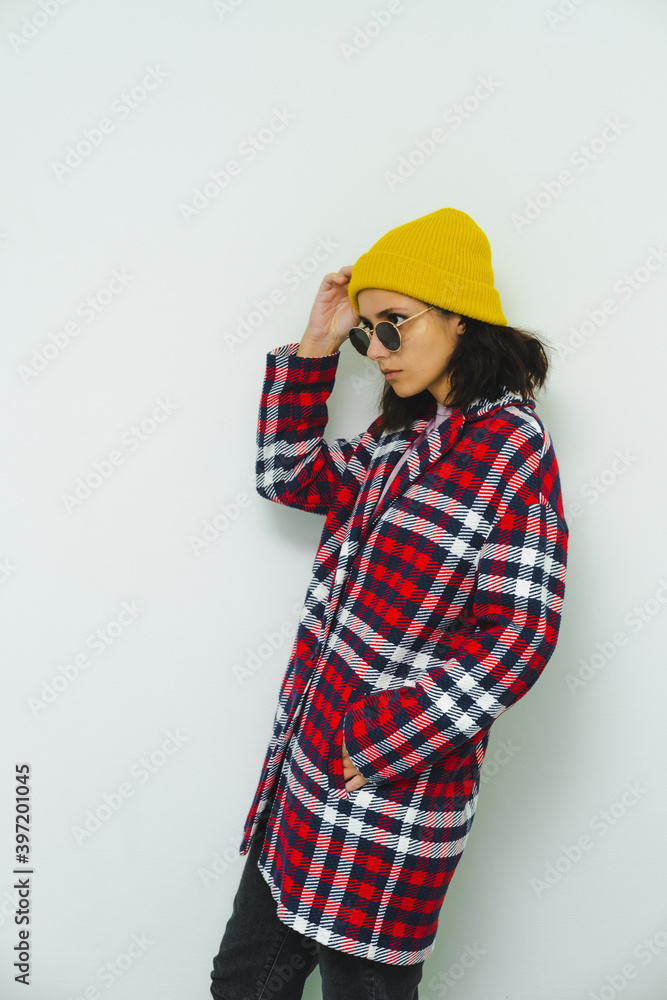 Model in fashion urban street outfit. Stylish posing. Trendy red coat and yellow beanie. Fall winter seasons lookbook Model in fashion urban street outfit. Stylish posing. Trendy red coat and yellow beanie. Fall winter seasons lookbook