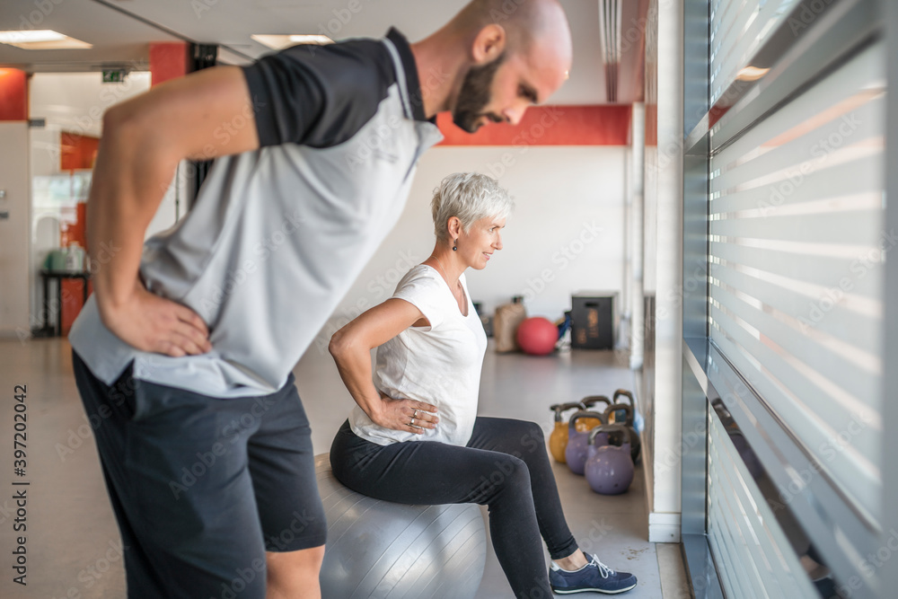Pregnant woman exercising with personal trainer Pregnant woman exercising with personal trainer