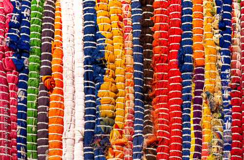 Background - a fragment of a rug made of multi-colored fabrics. Hand-made carpet.