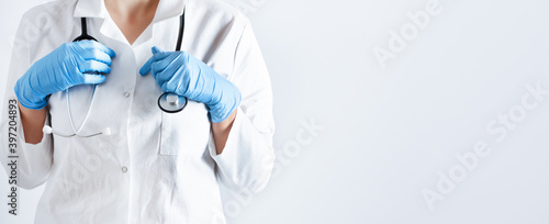 Fototapeta Naklejka Na Ścianę i Meble -  Doctor in a lab coat and surgical gloves with stethoscope over white background.