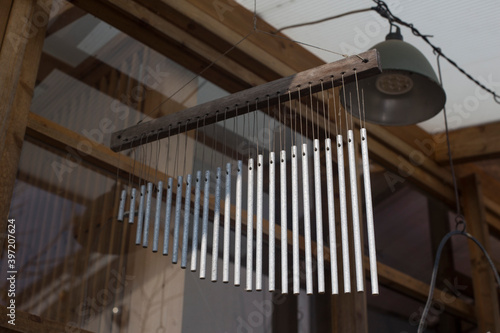 Billede på lærred Unique handmade wind chime on house background.