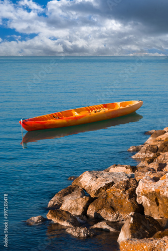 Canoe anchored by rocky water front