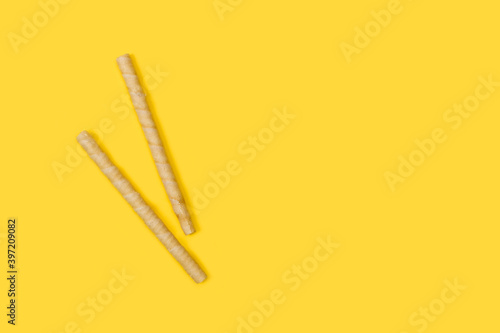 Waffle roll, palitos de rollo de obleas rellenas y crujientes sobre un fondo amarillo liso y aislado. Vista superior. Copy space photo