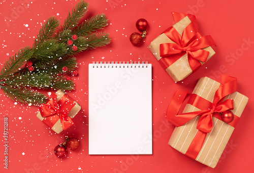 Christmas gifts boxes toys blank notepad red background Festive New Year concept