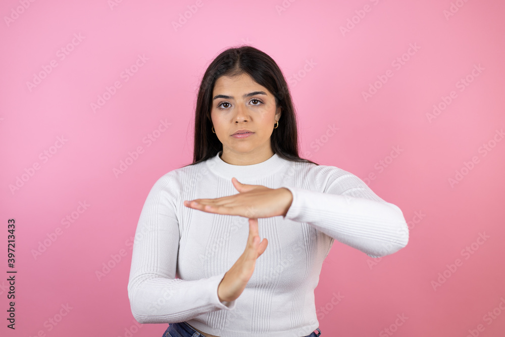 Young beautiful woman over isolated pink background Doing time out gesture with hands, frustrated and serious face Young beautiful woman over isolated pink background Doing time out gesture with hands, frustrated and serious face