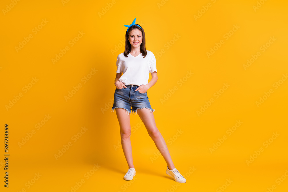 Full length photo of nice cheerful girl wear casual outfit pose hold hands in pockets isolated on bright yellow color background Full length photo of nice cheerful girl wear casual outfit pose hold hands in pockets isolated on bright yellow color background