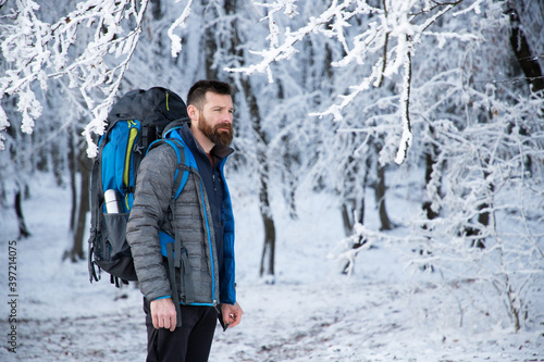 handsome man trekking in beautiful winter landscape social distancing