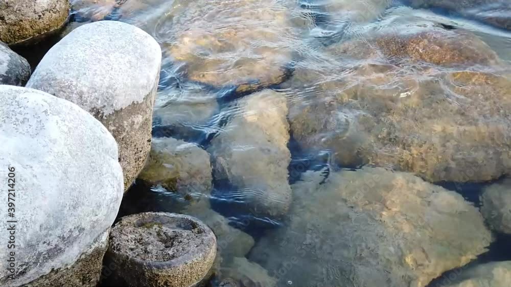 Close-up view or rocks under clear, rippling water on summer day. Shallow water. Outside. Close-up view or rocks under clear, rippling water on summer day. Shallow water. Outside.