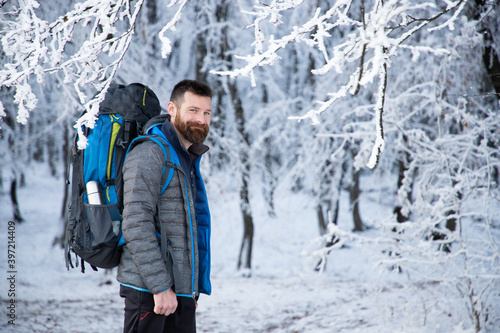 handsome man trekking in beautiful winter landscape social distancing