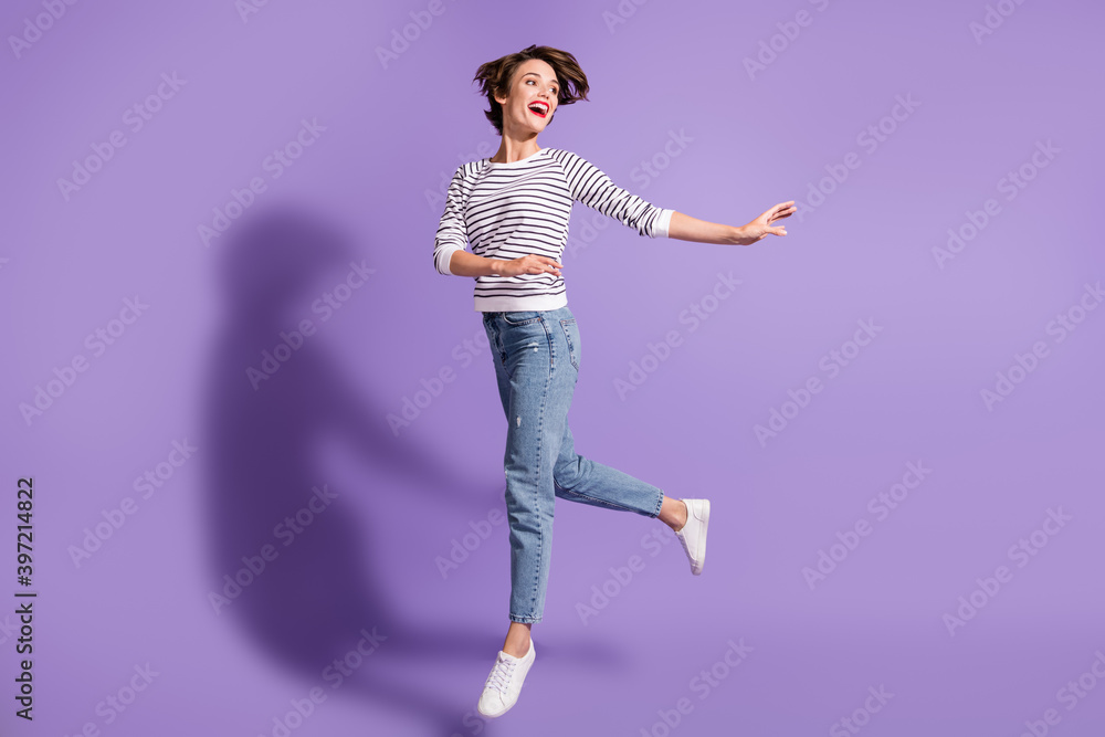 Full length photo of shiny young woman wear casual outfit dancing arms hands side standing one leg isolated violet color background
