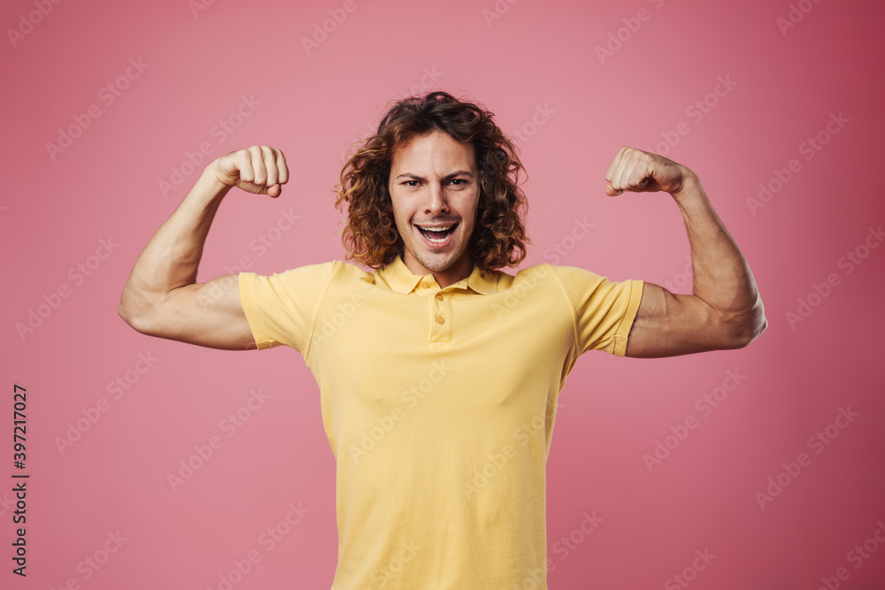Delighted handsome guy smiling and showing his biceps Delighted handsome guy smiling and showing his biceps