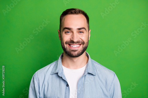 Portrait of optimistic funny man wear blue shirt isolated on green color background