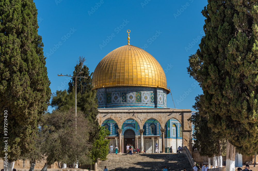 Obraz premium The Golden Dome of the Rock, or Qubbat al-Sakhra, and stone gate ruins in an Islamic shrine located on the Temple Mount in the Old City of Jerusalem.