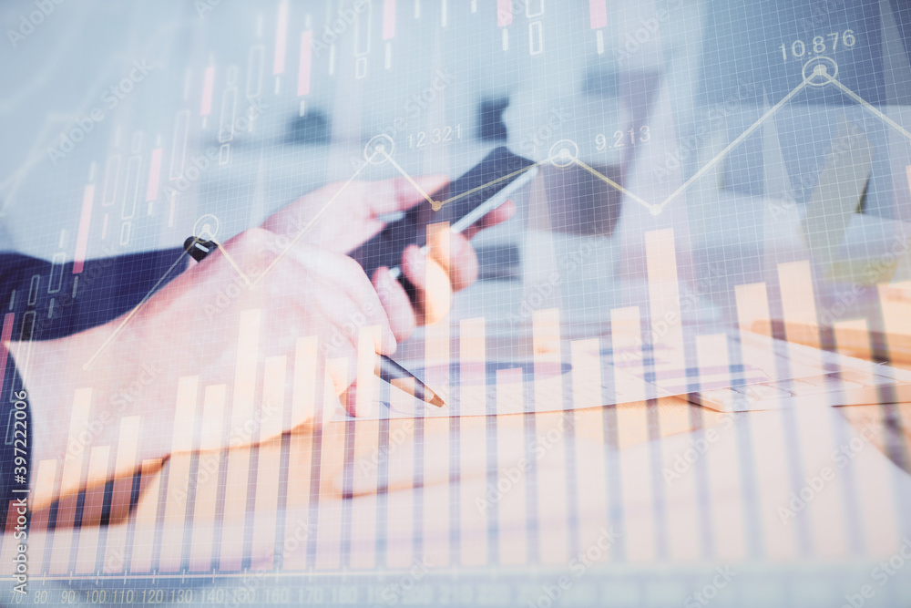 Double exposure of man's hands holding and using a phone and financial graph drawing. Analysis concept. Double exposure of man's hands holding and using a phone and financial graph drawing. Analysis concept.