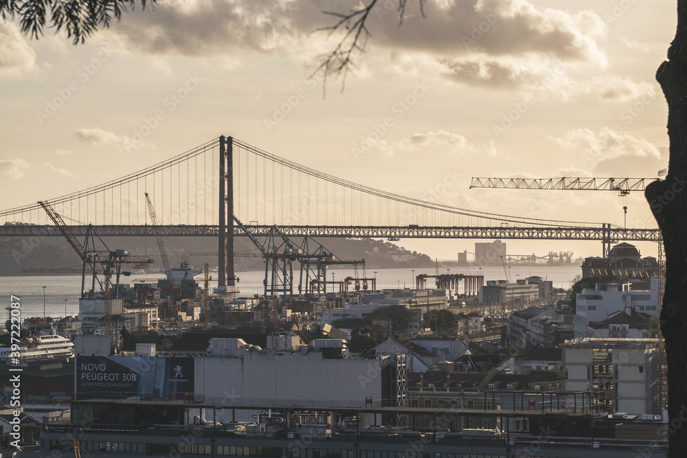 Obraz premium Ponte 25 de Abril with industry zone of Lisbon in forefront. Most famous bridge in Portugal. Lisbon. Red bridge.