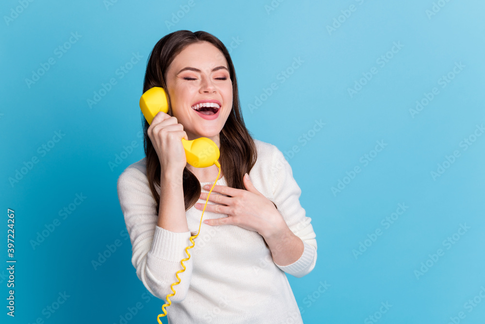 Photo of funny curly woman dressed white pullover talking vintage phone arm chest closed eyes isolated blue color background Photo of funny curly woman dressed white pullover talking vintage phone arm chest closed eyes isolated blue color background