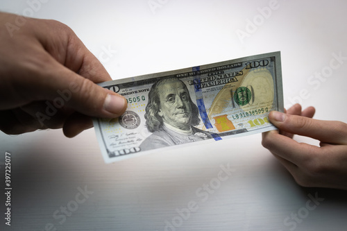 textured background of one hundred dollar bill with a portrait of us President Franklin in orange, red and black colors. blur, defocus.
