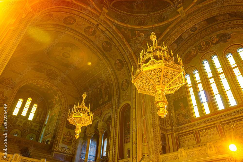 Bottom view to Interior of Orthodox Church and hanged golden chandeliers