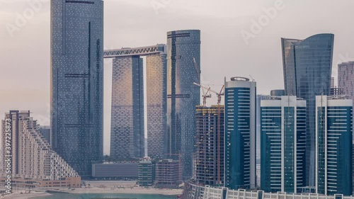 Skyscrapers on Al Reem Island in Abu Dhabi timelapse from above. Aerial citiscape from Al Reem Island at morning with heavy fog photo