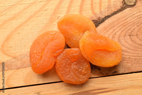 Bright orange natural dried apricots, close-up, on a wooden table.