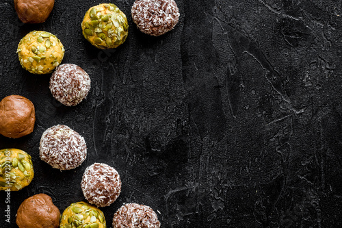 Flat lay of raw protein energy balls with nuts and cacao, top view