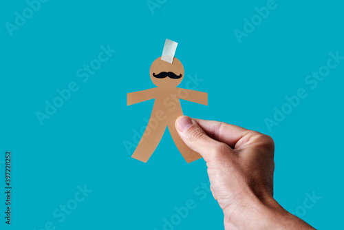 man with a paper man doll in his hand photo