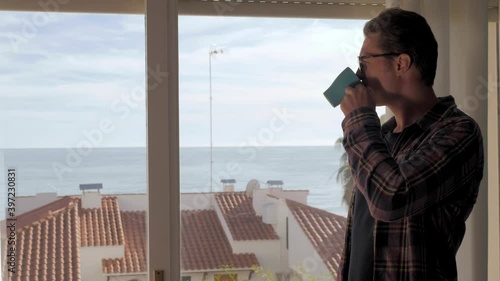 Handsome business man freelancer message using voice recognition, speaking at smartphone on sunset silhouette. Helper voice search, man in luxury hotel apartments with sea view