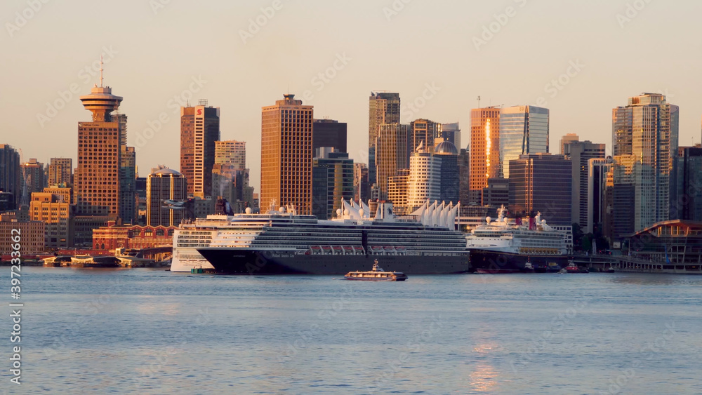 Fototapeta premium Vancouver, BC, Canada: Skyline of the downtown with the cruise ships docked in the early morning. Golden hour.