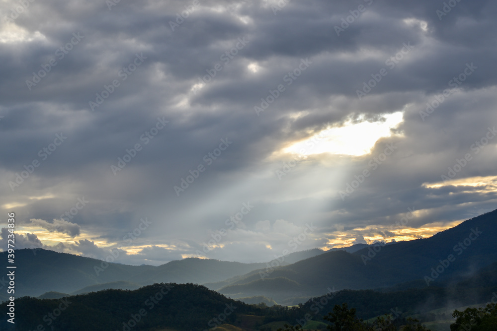 Wide angle view, Sunlight shines from the sky, there are thick clouds among the valleys and nature.