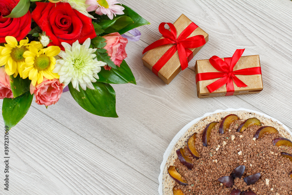Fototapeta premium Chocolate cake decorated with plums and flowers