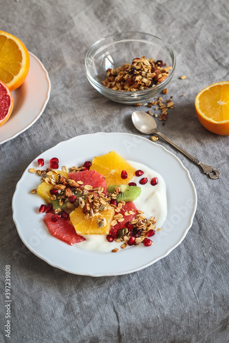 Morning table setting with colorful citruses, yogurt and homemade granola