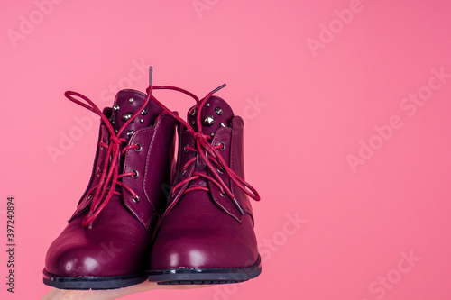 close up photo burgundy lace-up boots in pink studio