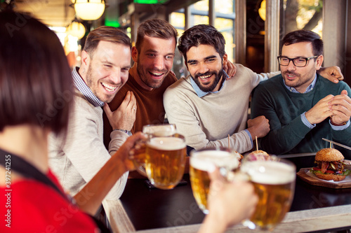 Group of four friends enjoying in beer pub