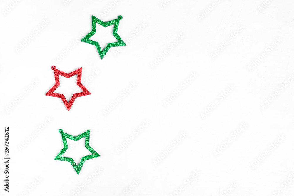 Obraz premium Three glittering star shaped decorations against the white background. Copy space. Minimalist festive background