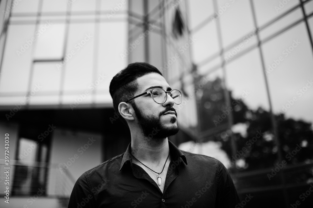 Middle eastern entrepreneur wear blue shirt, eyeglasses against office building. Middle eastern entrepreneur wear blue shirt, eyeglasses against office building.