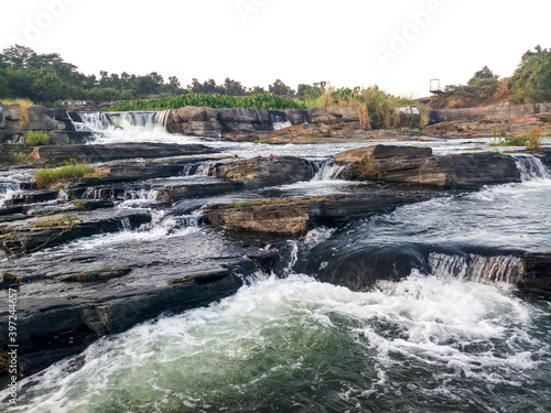 View of a magnificent ‘Bhatinda’ waterfall in the middle of the green forest surrounded by low hills which located in the Dhanbad district in the Indian state of Jharkhand photo