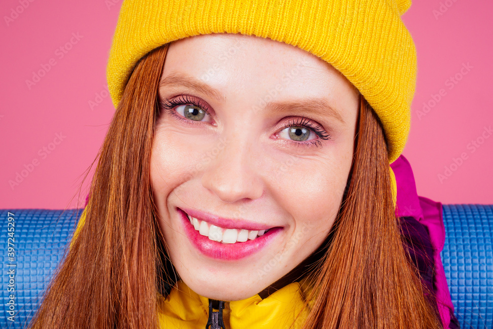 Happy woman ready for travel to mountains in new yellow jacket Happy woman ready for travel to mountains in new yellow jacket