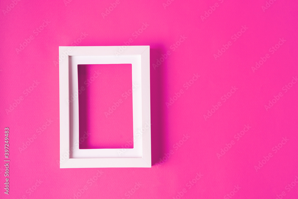 Minimalistic style. A white blank picture frame on pink background , flat lay Minimalistic style. A white blank picture frame on pink background , flat lay