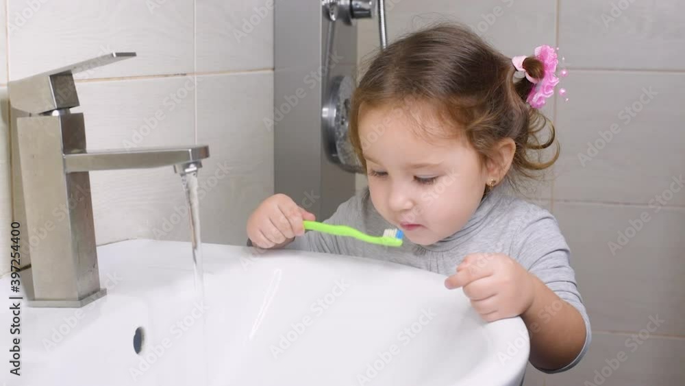 Cute girl in the bathroom brushing her teeth Cute girl in the bathroom brushing her teeth