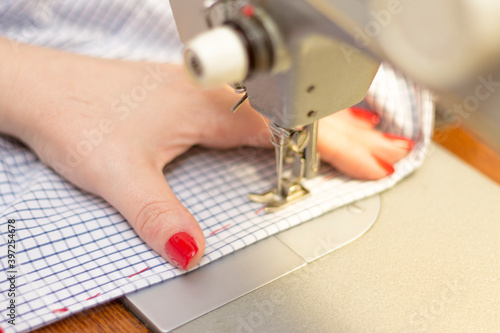 Woman taylor is working on a sewing machine