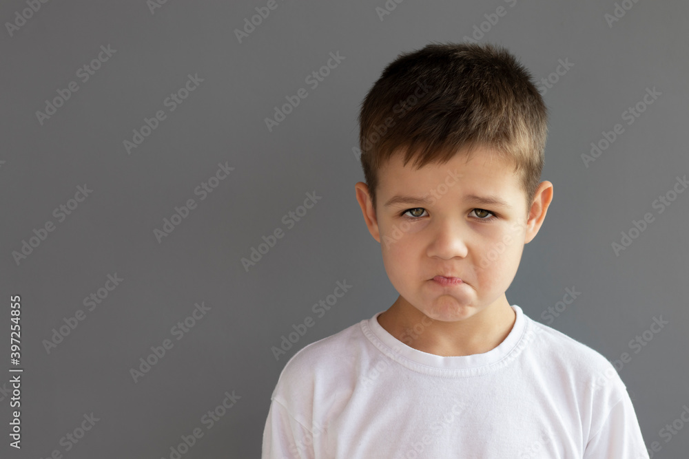 Offended little boy , on gray background Offended little boy , on gray background
