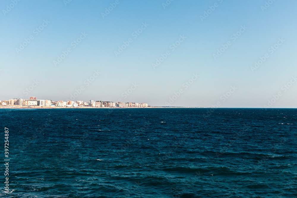 Sea waves and a city in the background