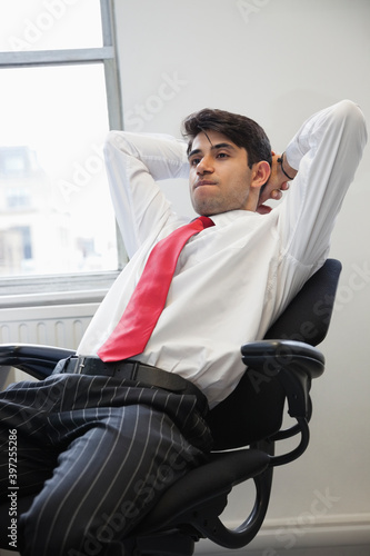 Young Indian businessman contemplating while sitting in office chair