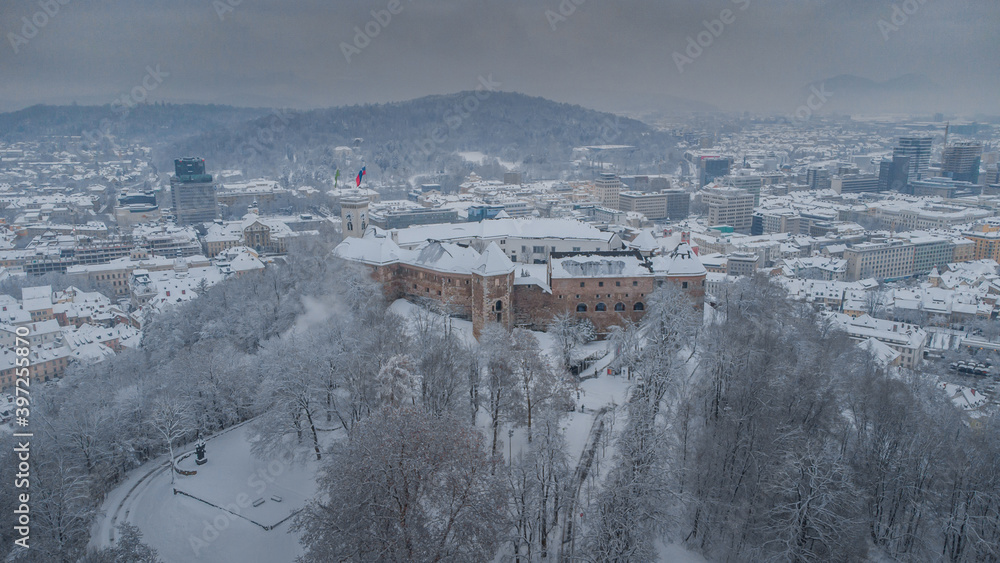 Obraz premium Winter aerial panorama of the city of Ljubljana with Castle as the highlight in the centre. Downtown Ljubljana Slovenia covered with snow.