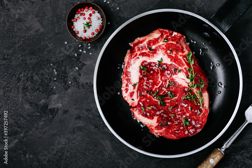 Fresh Raw Rib Eye Steak in frying pan prepared for cooking, barbeque, grill.
