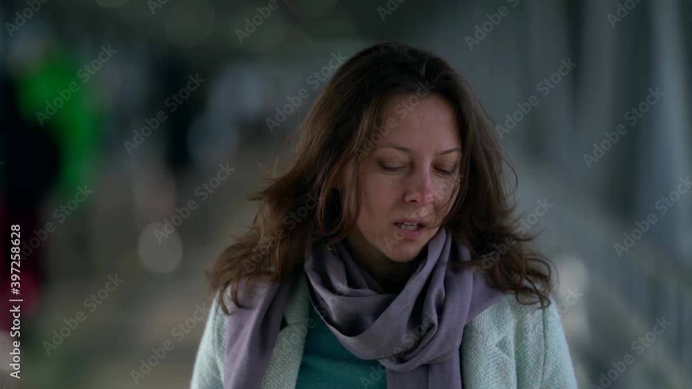 Portrait of an emotional middle-aged brown-haired woman who is walking in a crowded pedestrian crossing, wearing a coat and scarf. Portrait of an emotional middle-aged brown-haired woman who is walking in a crowded pedestrian crossing, wearing a coat and scarf.